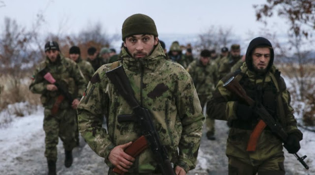 Pro-Russian separatists from the Chechen "Death" battalion walk during a training exercise in the territory controlled by the self-proclaimed Donetsk People's Republic, eastern Ukraine, December 8, 2014. Chanting "Allahu Akbar" (God is greatest), dozens of armed men in camouflage uniforms from Russia's republic of Chechnya train in snow in a camp in the rebel-held east Ukraine. They say their "Death" unit fighting Ukrainian forces has 300 people, mostly former state security troops in the mainly-Muslim region where Moscow waged two wars against Islamic insurgents and which is now run by a Kremlin-backed strongman. Picture taken December 8, 2014. REUTERS/Maxim Shemetov (UKRAINE - Tags: POLITICS CIVIL UNREST CONFLICT)