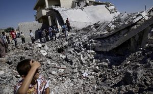 FILE - In this Monday, Sept. 3, 2012 file photo, Syrians gather by the rubble of a house, destroyed from Syrian forces shelling, in the Syrian town of Azaz, on the outskirts of Aleppo, Syria. Relentless shelling and airstrikes have killed more than 300 civilians in the city since rebels broke through a government blockade of the opposition-held east on July 31, 2016. (AP Photo/Muhammed Muheisen, File)