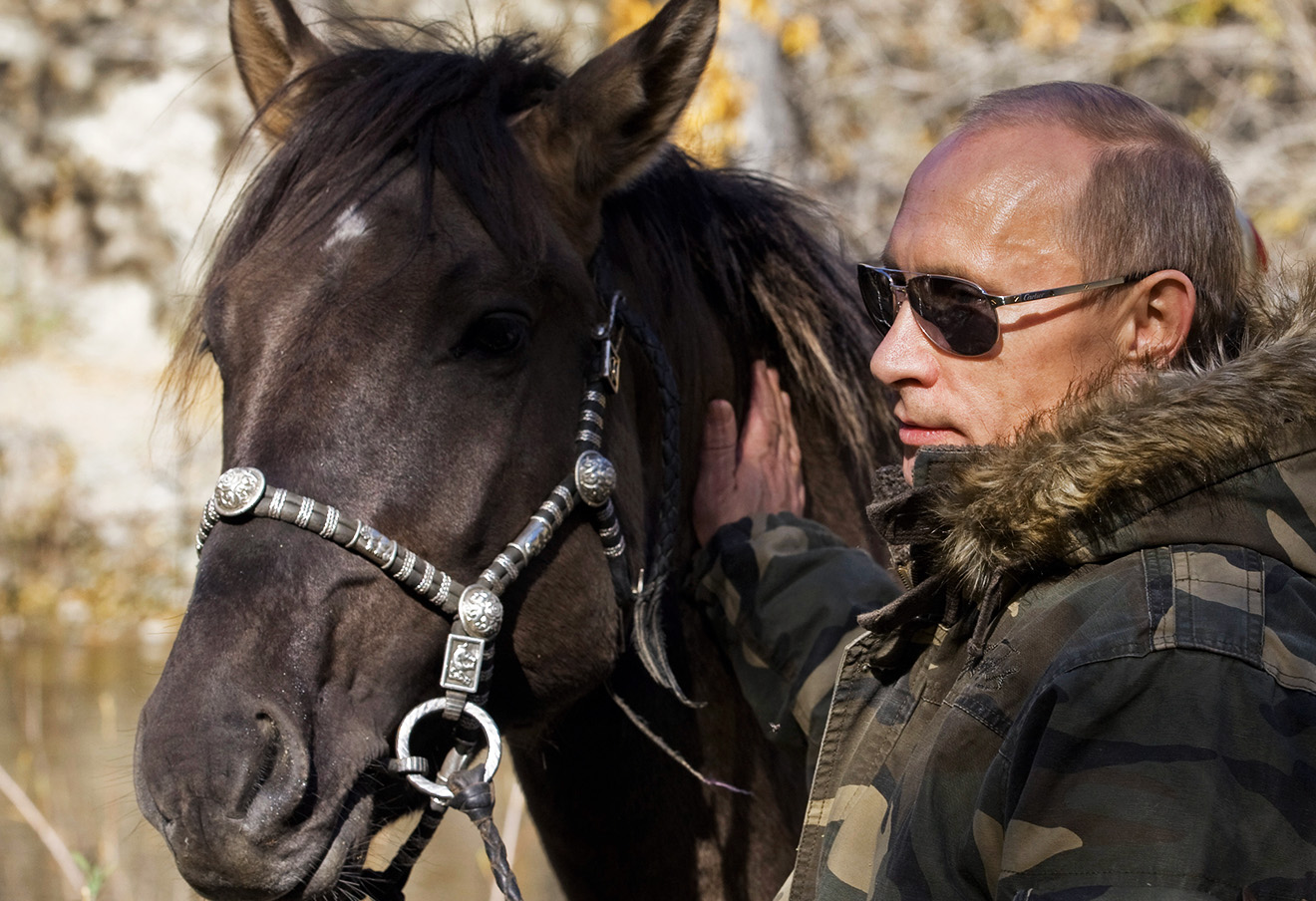 In this Sept. 2010 photo released on Saturday, Oct. 30, 2010, Russian Prime Minister Vladimir Putin pats a horse during his trip in Ubsunur Hollow in the Siberian Tyva region (also referred to as Tuva), on the border with Mongolia, Russia. (AP Photo/RIA Novosti, Alexei Druzhinin, Pool)